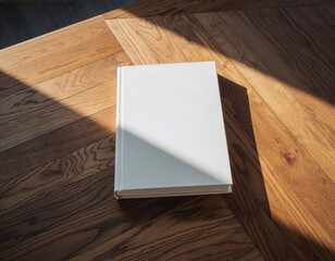 White book mockup on wooden desk with natural sunlight shadows