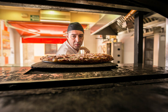 A pizzeria worker prepares the pizza dough and the bread of the day.