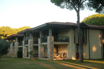Fototapeta premium Exterior view of hotel building with balconies and lawn.