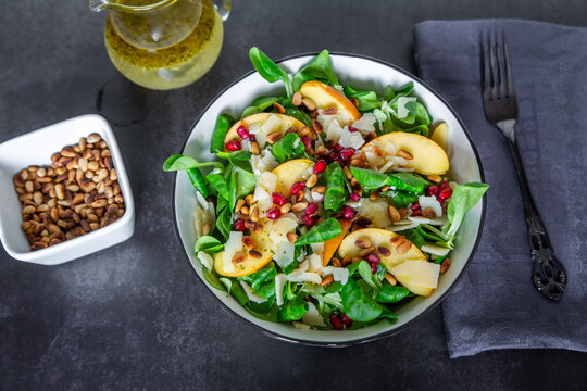 Lamb's lettuce salad with apple, pine nut and pomegranate in bowl