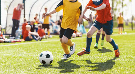 Obraz premium Youth Soccer Game Action; Kids Competing for Ball on Sunny Outdoor Football Field