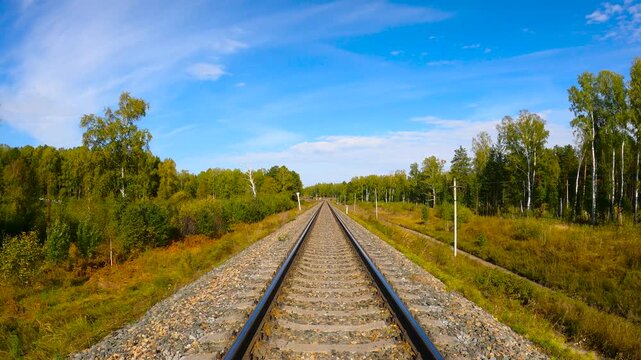 Walking on rails. A walk on rails in autumn, a man walks along rails into the distance in an autumn forest.
