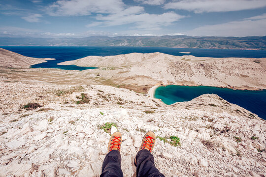 View of rugged, sun-baked terrain descends to meet the turquoise waters, a striking contrast under a vast sky, promising adventure and discovery, Ba&Aring;&iexcl;ka, Primorje-Gorski Kotar County, Croatia.