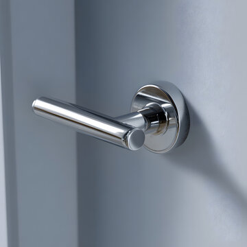 Single modern door handle on clean hallway door surface with right copy space macro detail