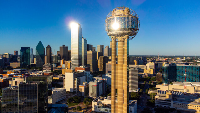 Aerial view of the iconic Reunion Tower piercing the skyline, its geodesic dome reflecting the sun's golden rays over the cityscape, Dallas, Texas, United States.