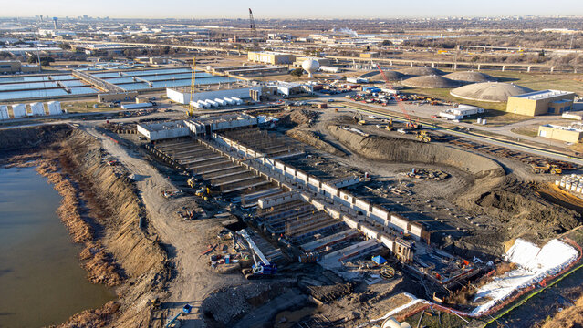 Aerial view of the intricate, geometric patterns of a construction site juxtaposed against the serene backdrop of water treatment facilities, Dallas, Texas, United States.