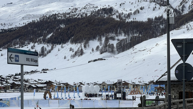 Livigno, Italy - February 12, 2026: Sign to OVL Village and Olympic Winter Games event area in snowy alpine valley