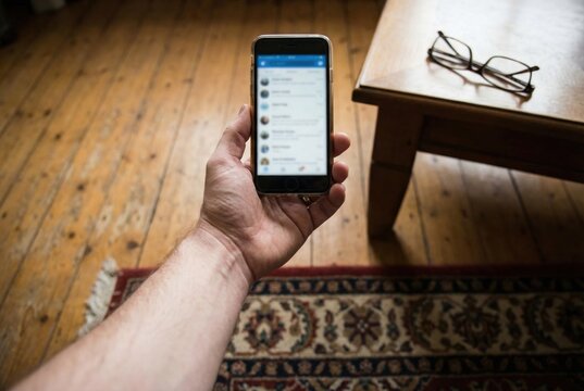 POV of hand holding smartphone with blurry screen at arm's length