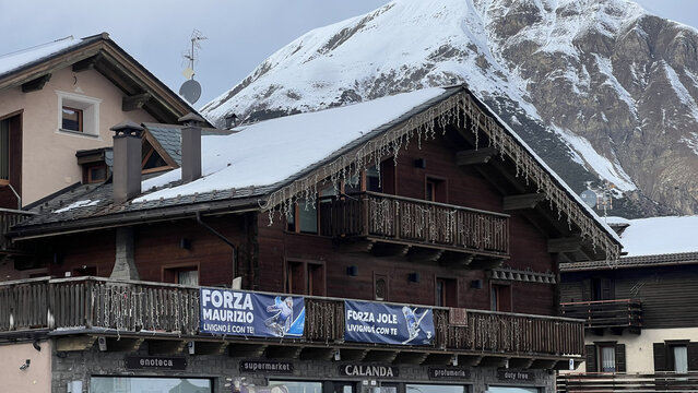 Livigno, Italy - February 12, 2026: Banners supporting local athletes Maurizio and Jole displayed on a wooden chalet during Milano Cortina 2026 Winter Olympic Games