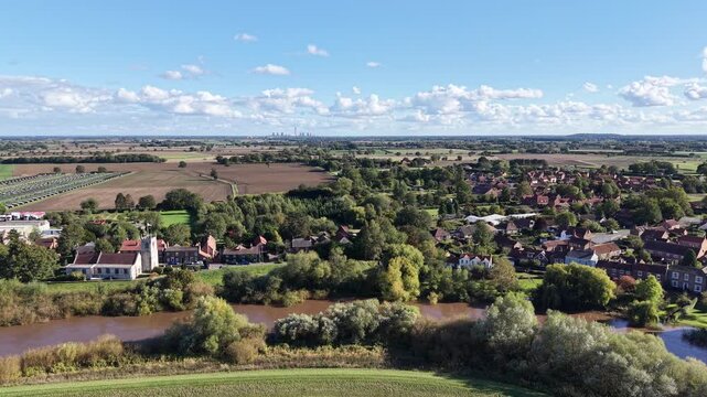 Aerial drone footage showing rural outskirts near Chiltern Hills in Buckinghamshire and Oxfordshire, England, with village houses, river, farmland, trees, and countryside.