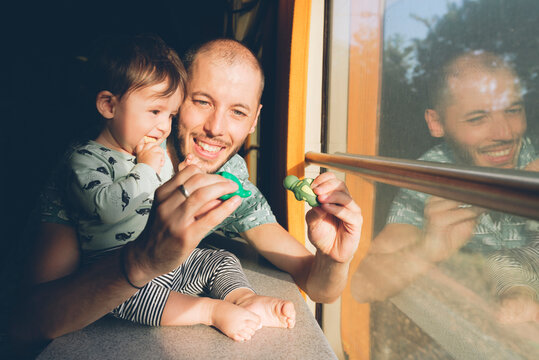 Father playing with his baby girl while traveling by train