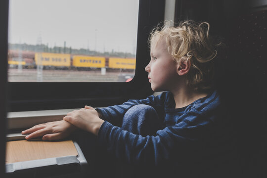 Little boy sitting in train looking out of window