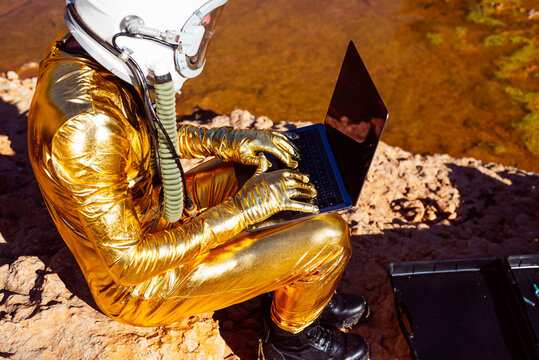 Astronaut using laptop while sitting on moon