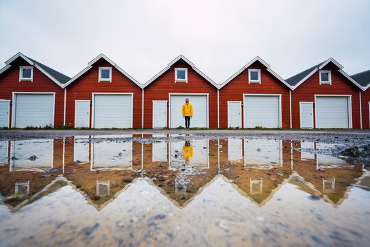 Norway, man standing in front of row of huts