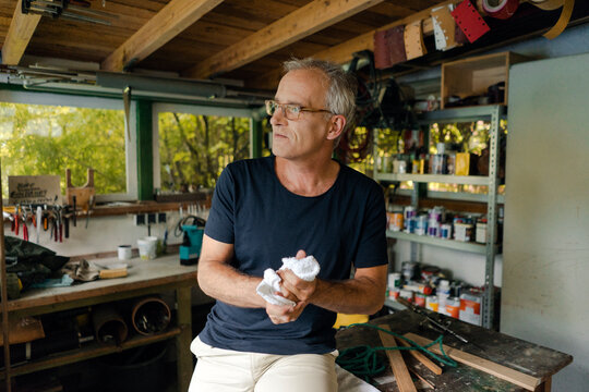 Mature man in his workshop cleaning his hands
