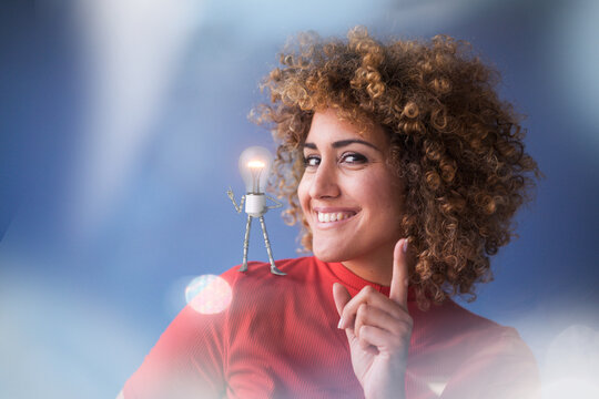 Portrait of smart woman with lightbulb on her shoulder