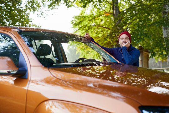 Mature man leaning on car in nature