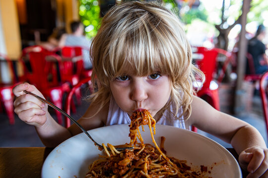 Girl eating spaghetti at restaurant
