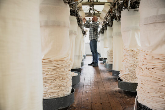 Worker adjusting circular knitting machine, threading yarn