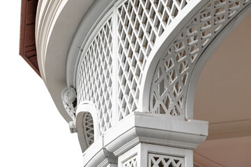 Close-up of a white lattice arch and carved columns