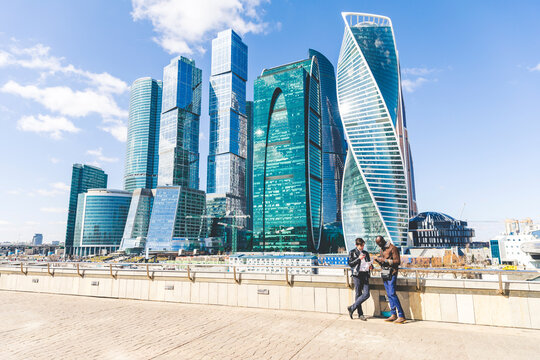 Russia, Moscow, two businessmen standing in front of modern office towers