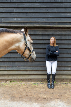 Young woman looking to her horse