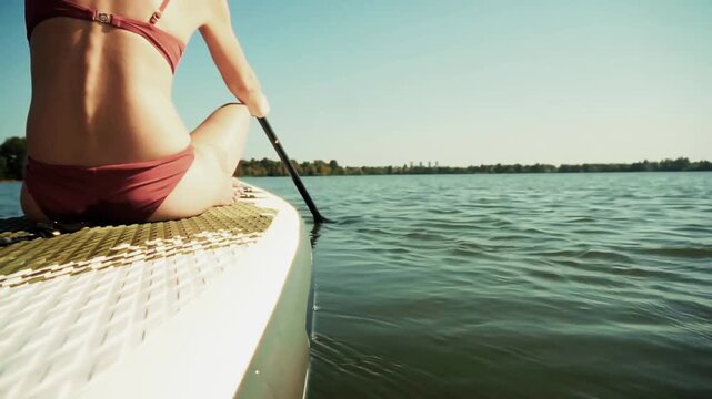 Active Surfer Using Oar For Fast Movement On SUP Board. Aquatic Recreation
