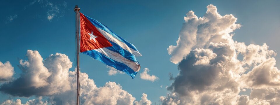 Cuban flag waving under blue sky with clouds during bright day in Cuba, showcasing national pride and identity