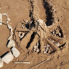 Sandcastle reinforced with stones and reed sticks &mdash; ideal for natural play, childhood creativity and ephemeral architecture documentation.