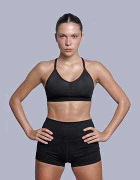 Young fitness woman looking at camera isolated on neutral background.