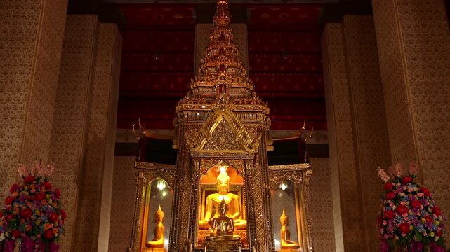 Golden Buddha statues inside the ornate ordination hall of Wat Paichayon Ponsep, Phra Pradaeng, Samut Prakan, Thailand.