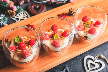 Verrine of crushed speculoos, mascarpone and raspberries on a gray background decorated for Christmas