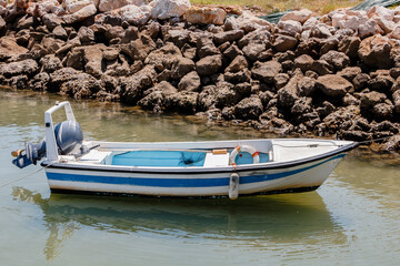 Small motorboat moored near a stone breakwater