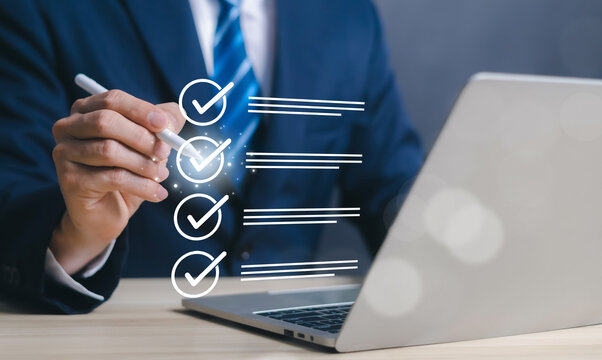 Checklist and quality control concept with businessman marking approved tasks on virtual interface near laptop. Project management, audit process compliance verification business workflow optimization