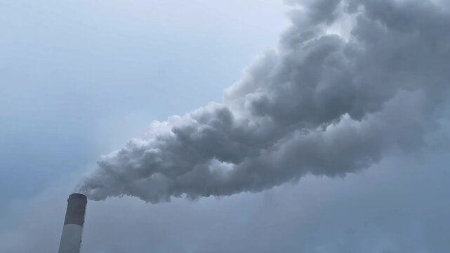 Factory chimney fumes emitting pollution to the atmosphere. Co2 and greenhouse gases emissions. The chimney emits exhaust gases into the blue sky. The concept of air pollution and the environment.	