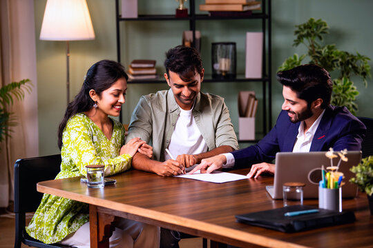 Indian Asian couple Home loan contract signing with banker during property purchase process