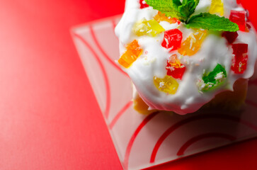 A colorful dessert with a green mint leaf on top © Q77photo