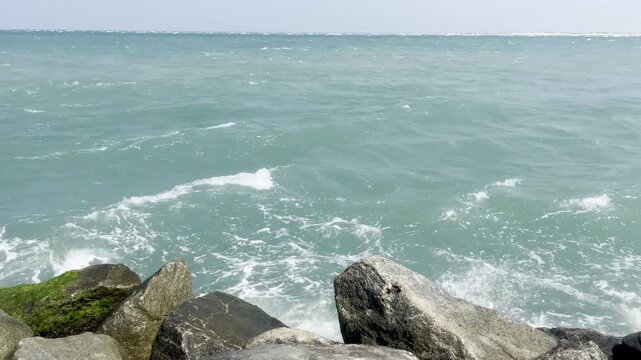 Closer view of a sea tide waves hitting the coastal rocks
