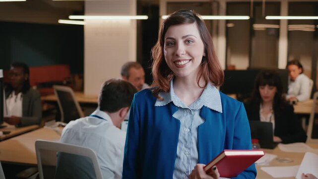 Confident businesswoman smiling at the camera in an open office space