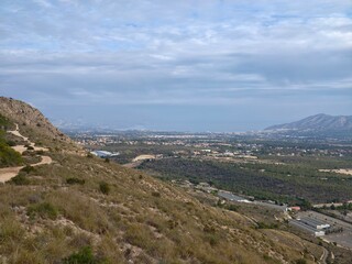 Fototapeta premium Charming hiking path through rocky terrain offering breathtaking views of nature and nearby urban backdrop