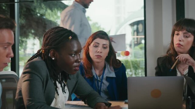 Diverse team collaborating on project in modern office meeting