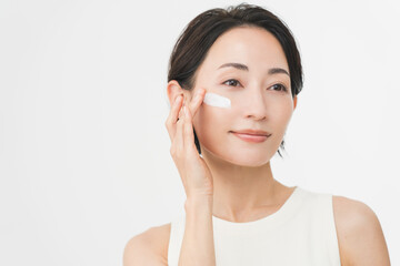 スキンケアプロセス。彼女は顔にクリームを塗っている。