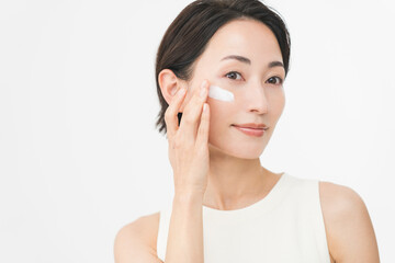 スキンケアプロセス。彼女は顔にクリームを塗っている。