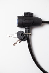 Fototapeta premium Close-up of black cable lock with attached keys on white background