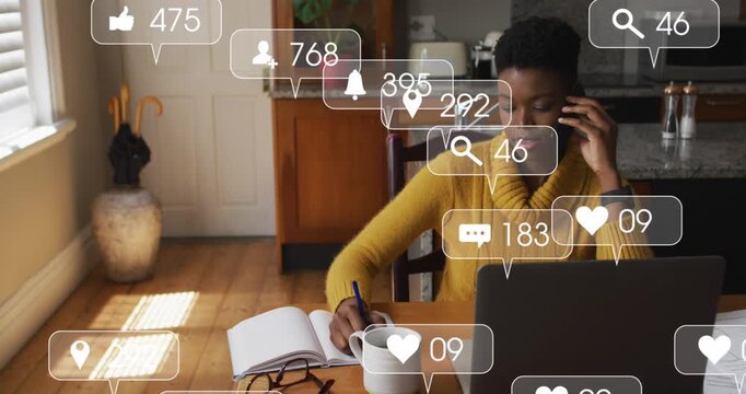 Animation of media icons floating over couple using computer