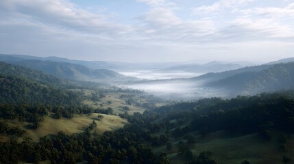 Obraz premium Serene aerial view of a misty valley at dawn with rolling green hills and soft morning light through clouds