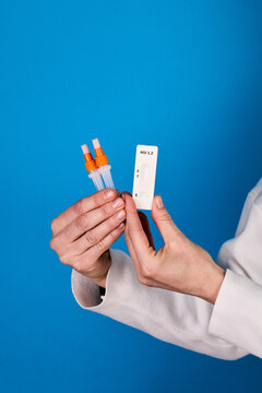 Physician&rsquo;s hands holding HIV 1.2 test and sample vials, focus on label and sterile handling procedure