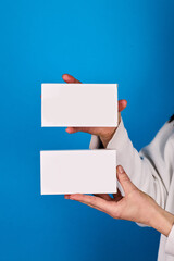 Obraz premium Two rapid test kits in hands, one slightly tilted to show label details, blue studio background, professional medical photography