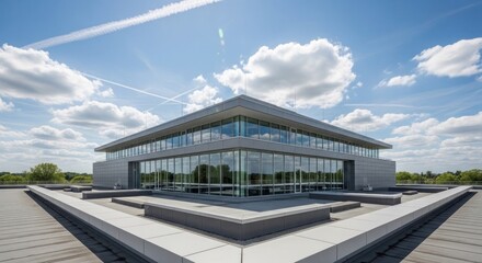 Obraz premium Modern glass building with sleek architecture and cloudy sky