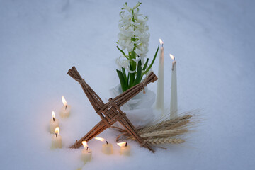 A Saint Brigid’s Imbolc altar with a woven Brigid’s cross, white hyacinth, lit candles, and wheat stalks is arranged outdoors on fresh snow, symbolizing early spring, purity, and Irish tradition.